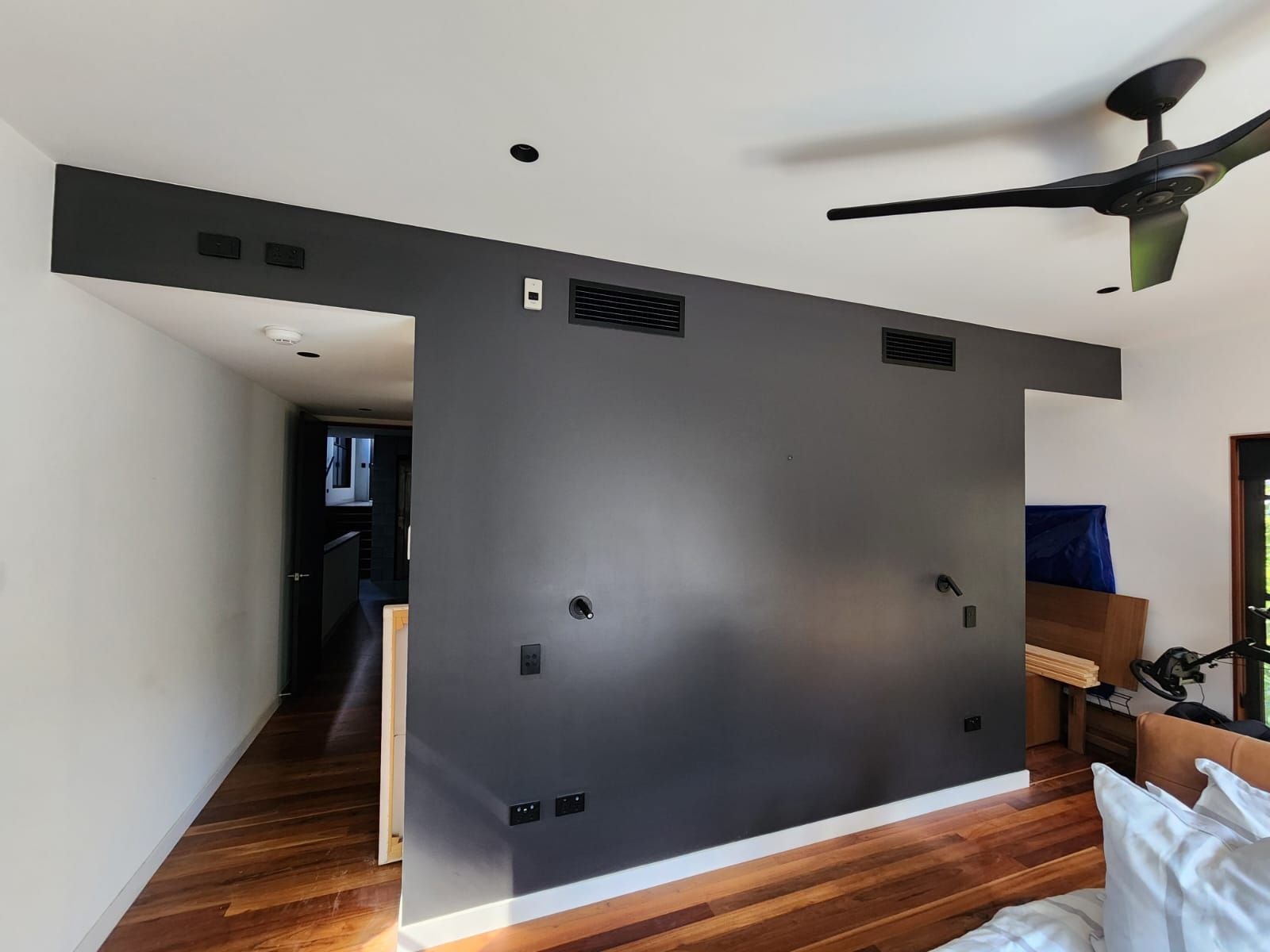 Charcoal feature wall over polished timber floors