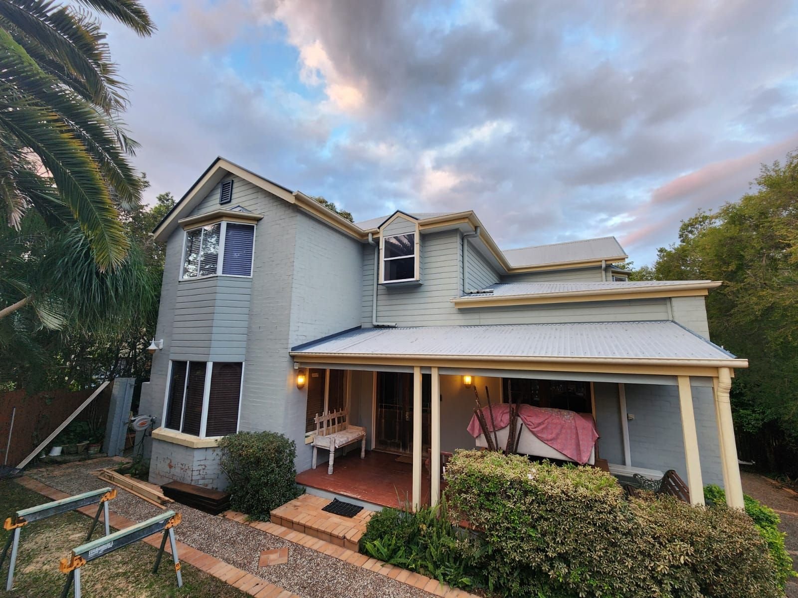 Repainted Queenslander facade photographed at dusk in Brisbane