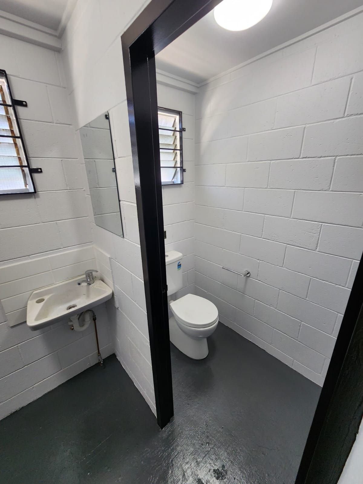 Repainted block walls and new fixtures in a bathroom